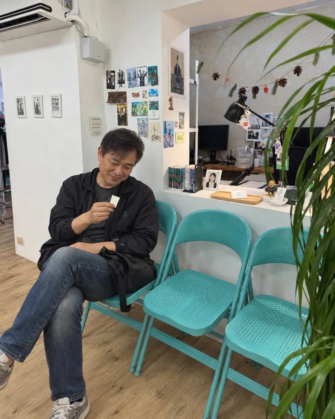 男子在等候區看著手中的舊照片，AI 情境圖